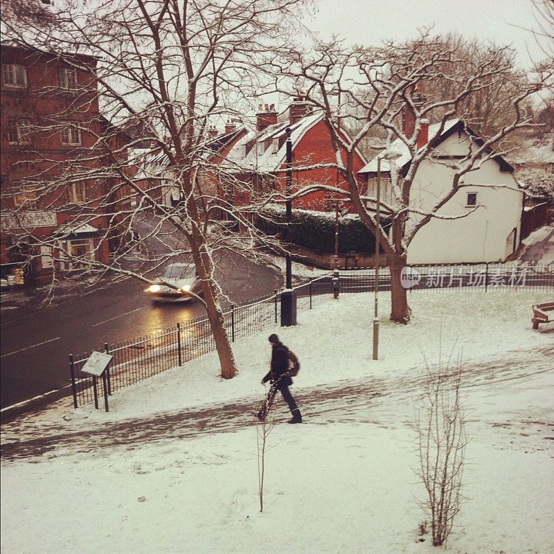 在英国牛津郡的冬季景色中，一个人在雪地里行走