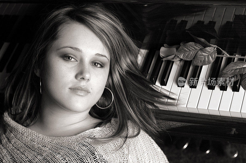 年轻女子躺在钢琴上的黑白图像