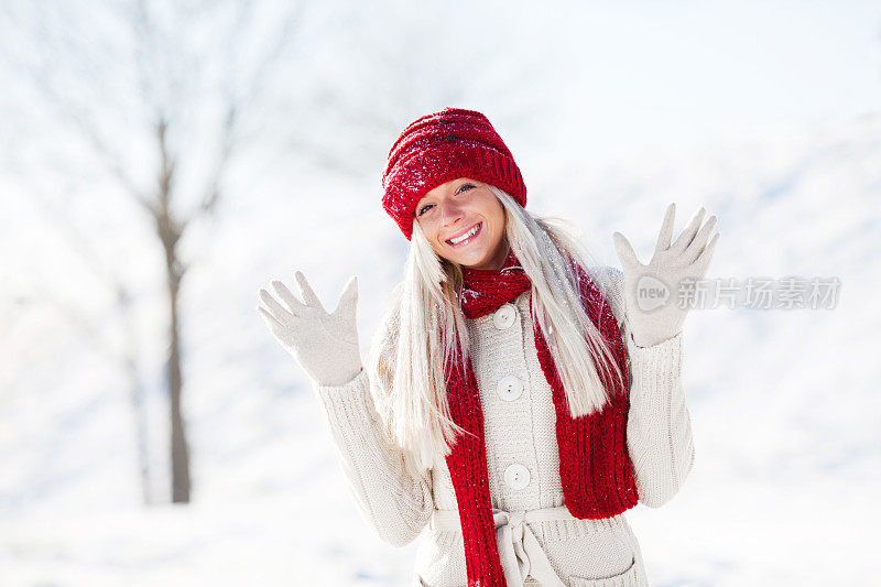 微笑的年轻女子享受在雪和冬天。