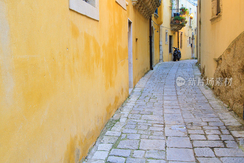 狭窄的老西西里鹅卵石小巷，明亮的黄色墙壁