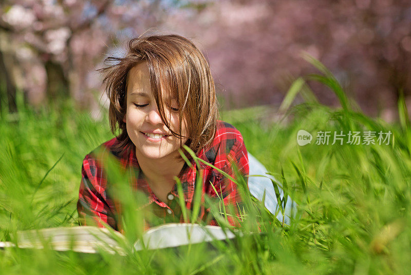 少年在樱花园里看书