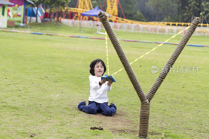 小女孩在玩弹弓。