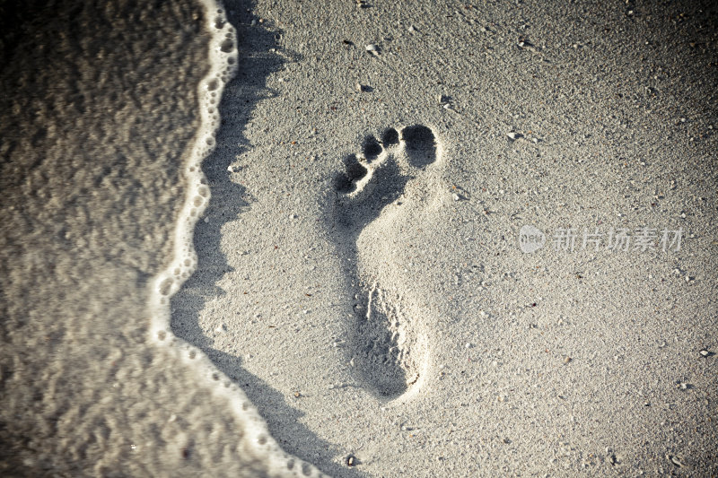 在吃水线附近的沙滩上留下脚印