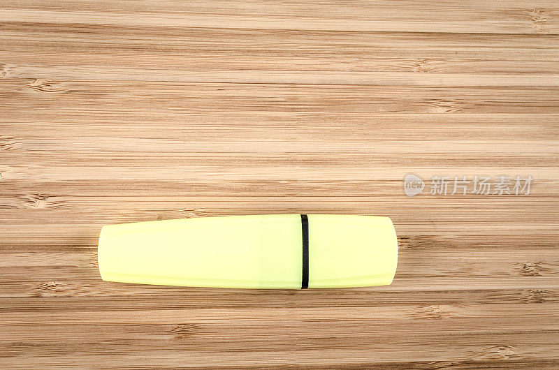 木制桌子上的黄色荧光笔