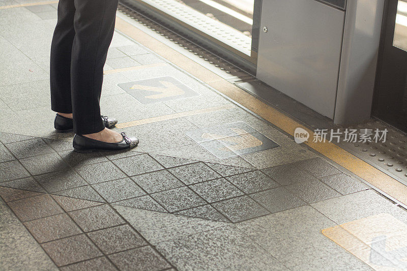 站在站台上等车的女人的脚