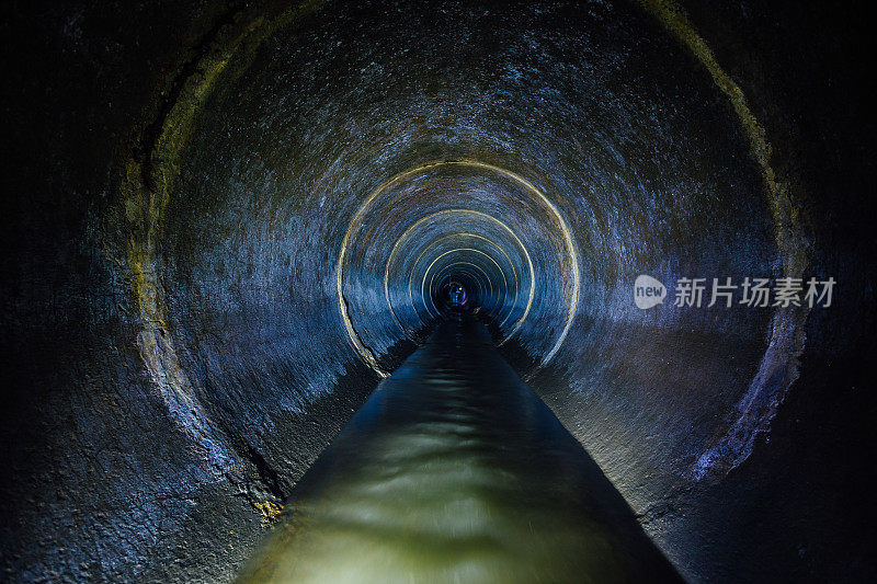 黑暗的地下下水道周围的混凝土隧道。工业废水和城市污水流动抛下水管道