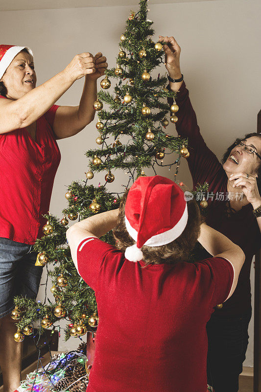 三个女人在布置圣诞树