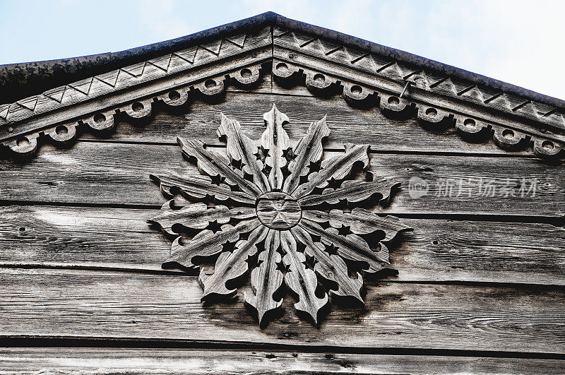 玫瑰形(装饰元素)上方的一个古老的俄罗斯木制房子的前门