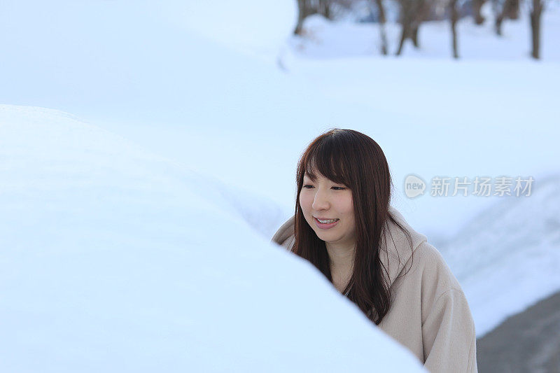 一个年轻女子从堆积的雪中出现