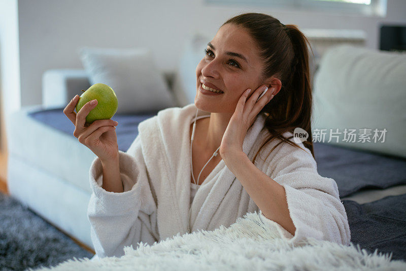 女人在家边听音乐边吃苹果