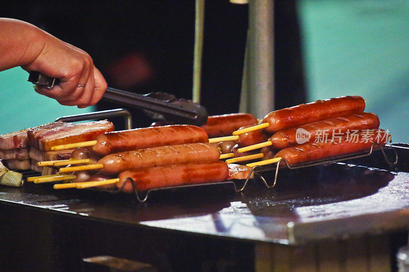 在第19届东京Yosakoi活动的晚上，在一个小吃摊上烤着弗兰克香肠和熏肉