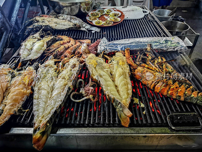 新鲜捕获的美味龙虾和王虾海鲜正在餐厅烧烤。