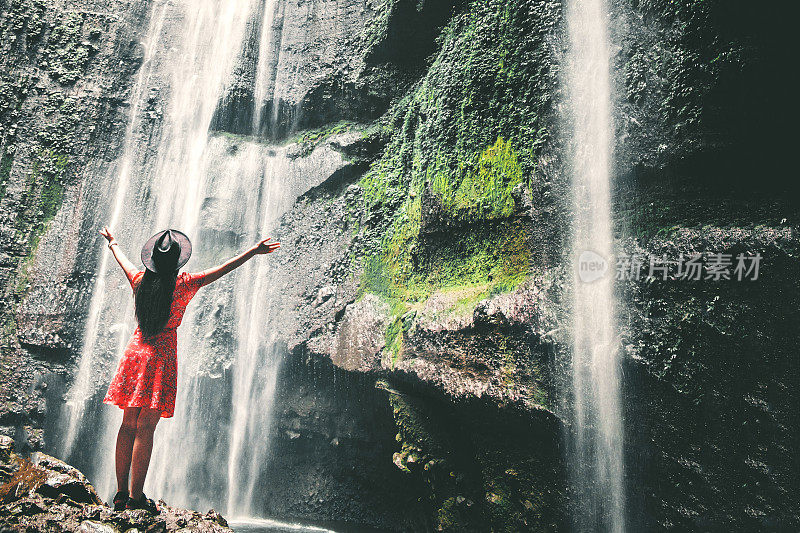 旅行女人冒险和站在Madakaripura瀑布放松，东爪哇岛，印度尼西亚