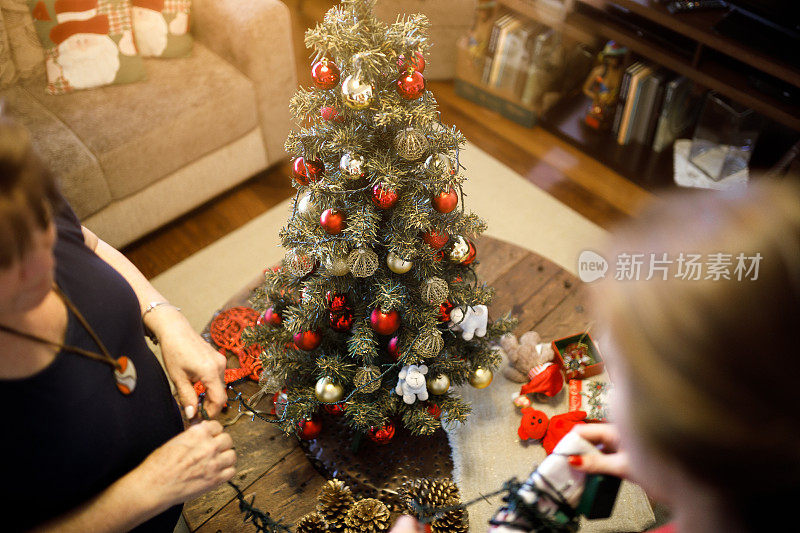 母亲和女儿装饰圣诞树