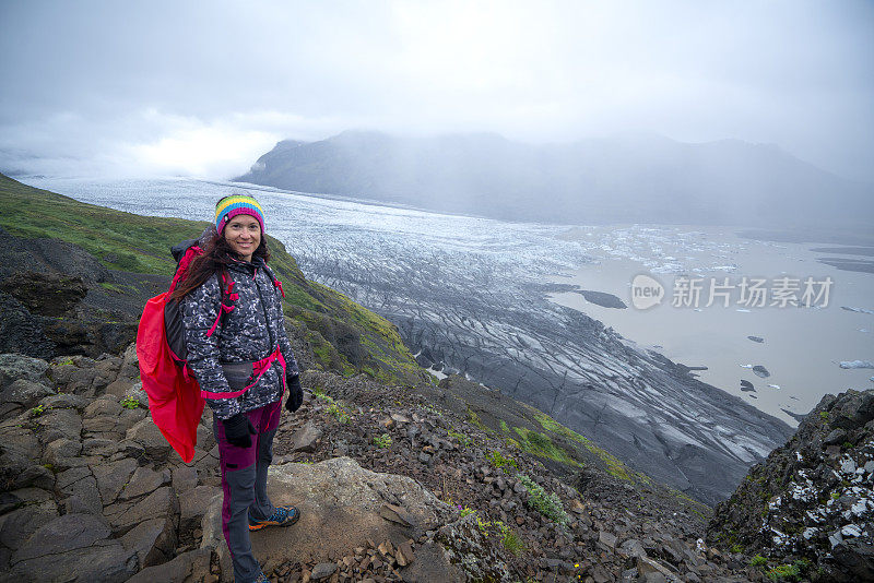 冰岛，在Vatnajokull冰川背景下的山顶上微笑的妇女