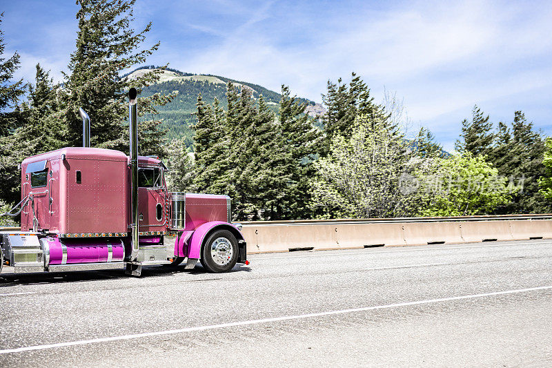 软棕色经典的大钻机半卡车驾驶室为卡车司机休息和粉红色的坦克和挡泥板与货物运行在哥伦比亚河峡谷国家休闲区宽阔的高速公路上