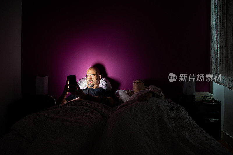 男人在床上玩手机