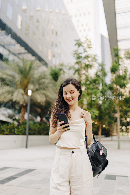 一个女人在街上用她的智能手机