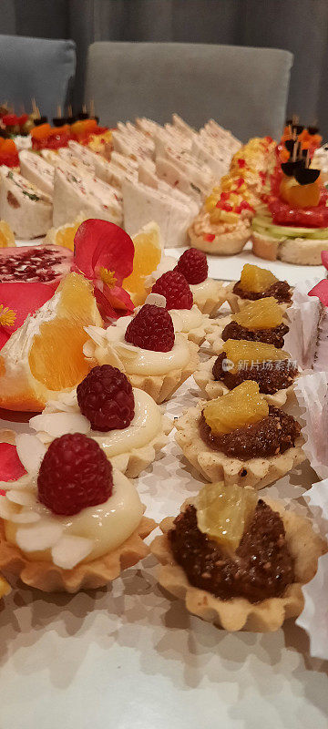 小甜饼、纸杯蛋糕和松饼摆放在一家大饭店的宴会桌上。