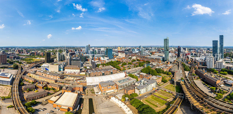 英国曼彻斯特的空中拍摄的现代建筑，在城市的中心地区有很多建设，前景是历史运河和铁路