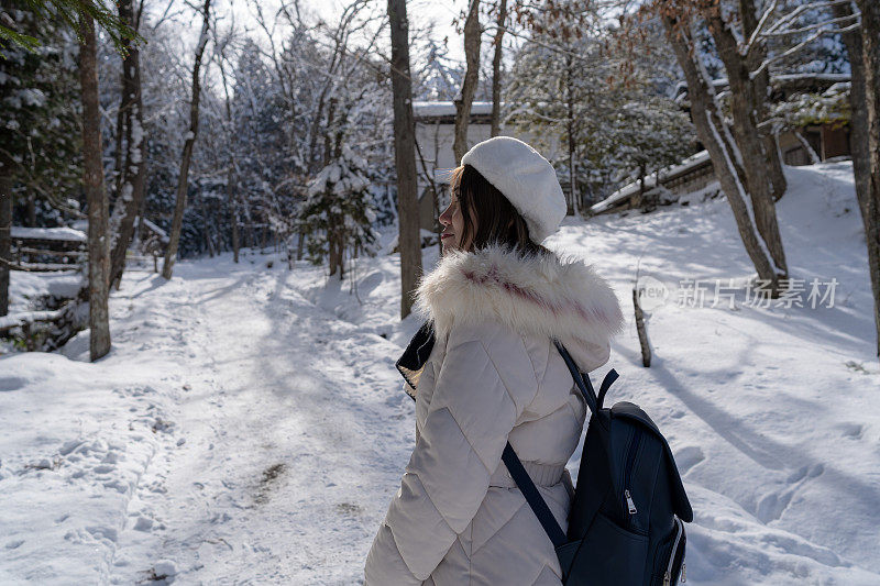 美丽的女子游客享受他们的日本之旅在雪的冬天