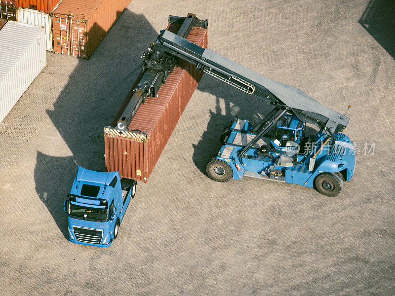 集装箱码头的卡车正在装载货运集装箱