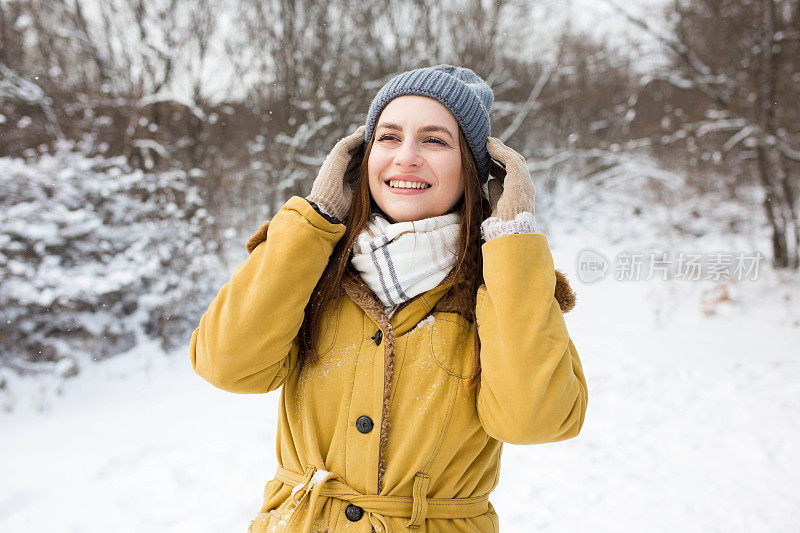 一个穿着黄色外套的漂亮女孩正期待着初雪的到来