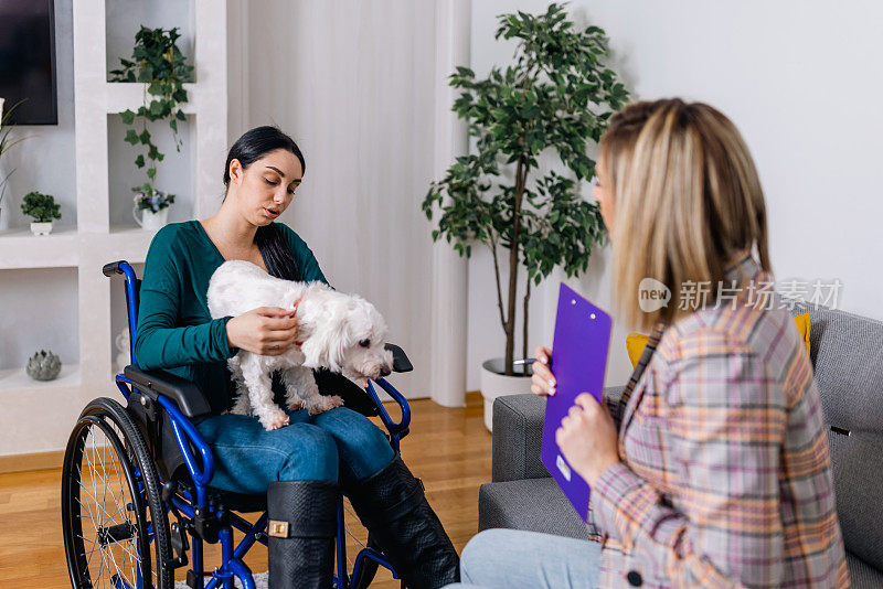 坐在轮椅上的年轻女子与她的治疗犬和心理治疗师在治疗中建立了深厚的联系