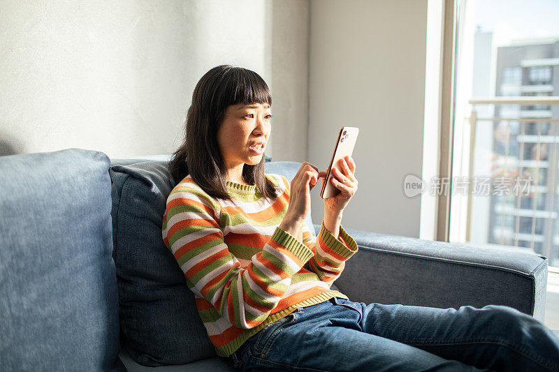 年轻的日本女性在家里使用智能手机