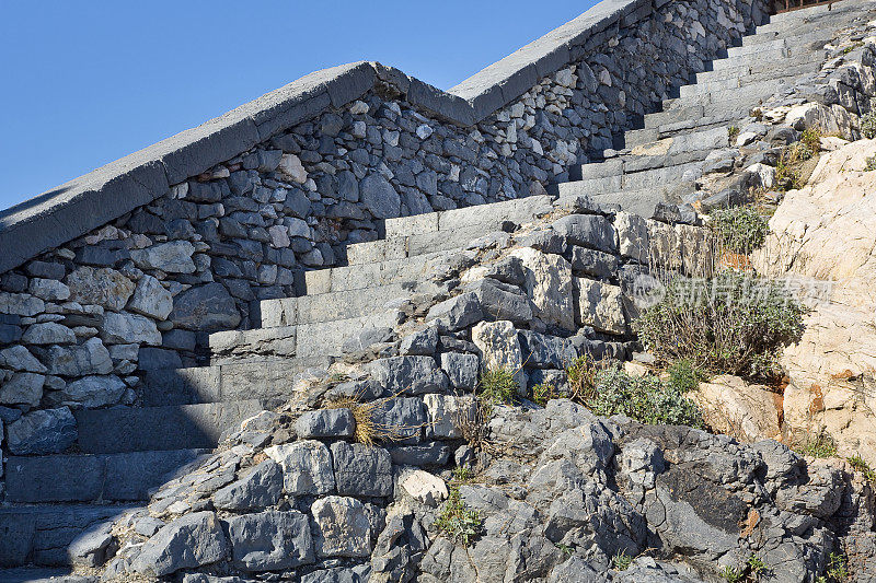 一个古老的石头楼梯和粗糙的石头栏杆的细节
