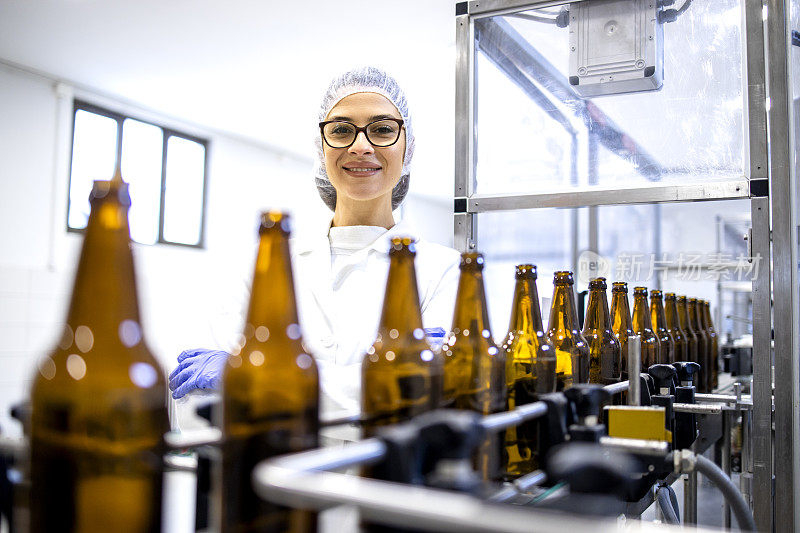 在酒精饮料装瓶厂控制啤酒生产的女工厂主管的肖像。