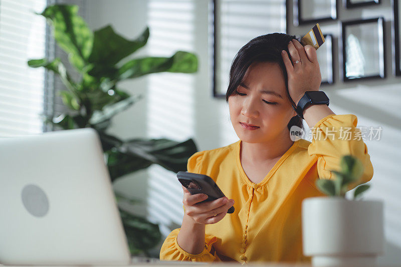 使用智能手机持有信用卡的亚洲女性在网上购物和支付时遇到了问题。