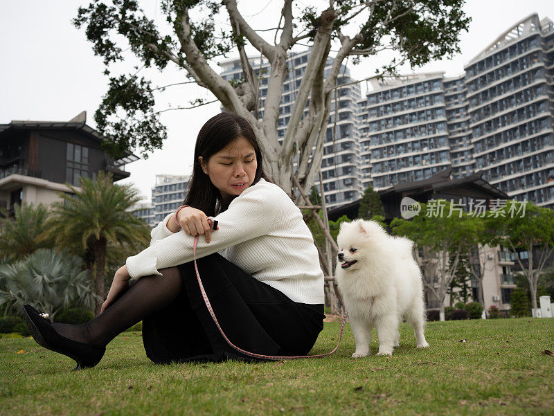 一个女人和她的狗在草地上休息