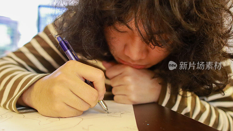 艺术学校的一名亚裔男生正在做设计作业