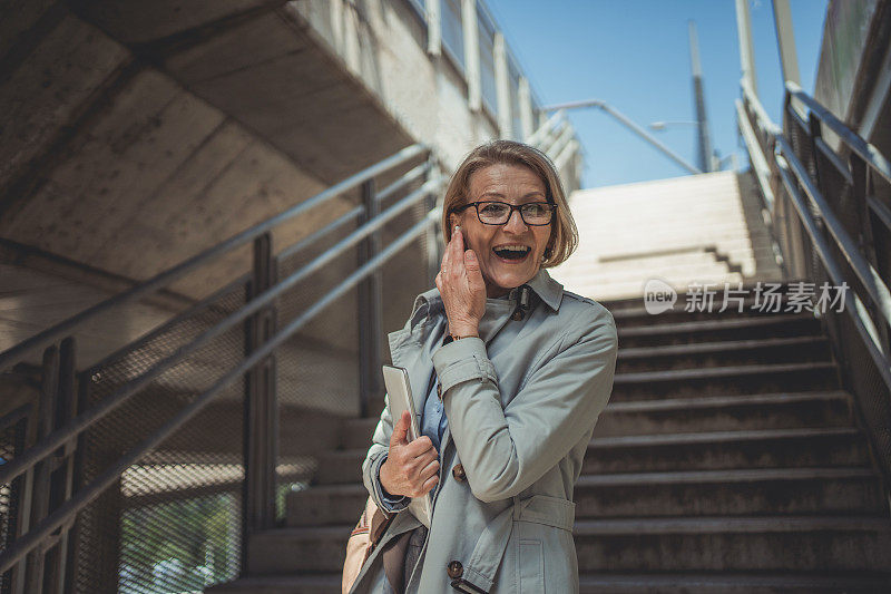 都市快乐的成熟女商人在上班时使用平板电脑