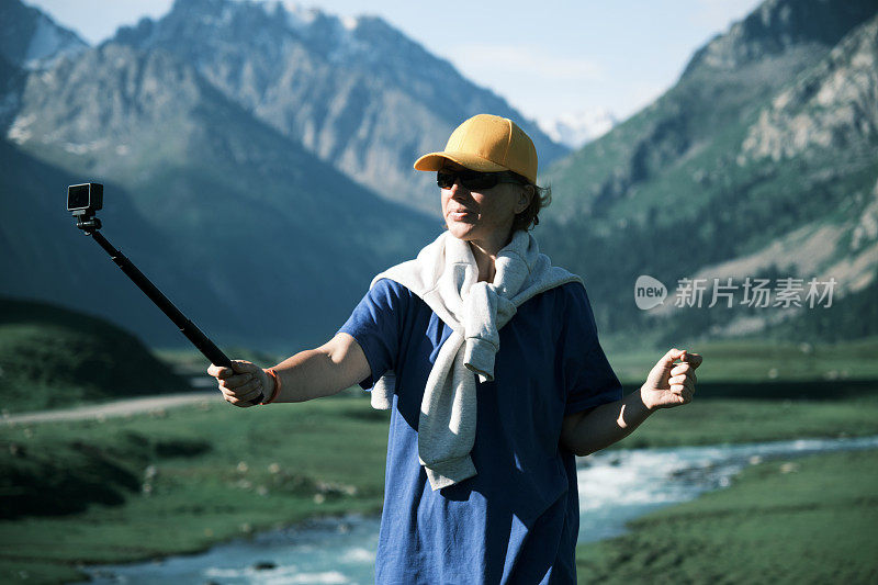 一位背包客正在拍摄她在山河上的旅行视频