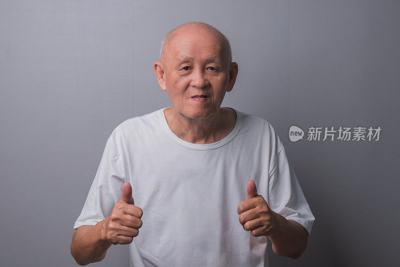 穿着白衬衫的亚洲秃顶老人竖起大拇指
