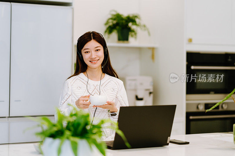 亚洲年轻女子对着摄像机视频通话，在家里与他的商业伙伴进行视频会议。