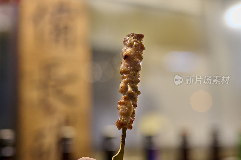 烤鸡肉串，日本传统的烤鸡肉。木桌上的烤盘和烤肉。烤烤鸡调味照片。日式烤鸡串。烹饪，餐厅，日本，东京。