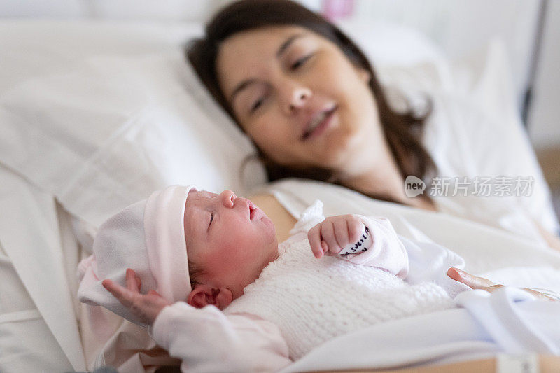 剖宫产后，一位母亲抱着刚出生的婴儿在医院