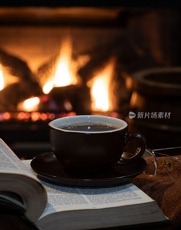 一杯咖啡，背景是燃烧的壁炉