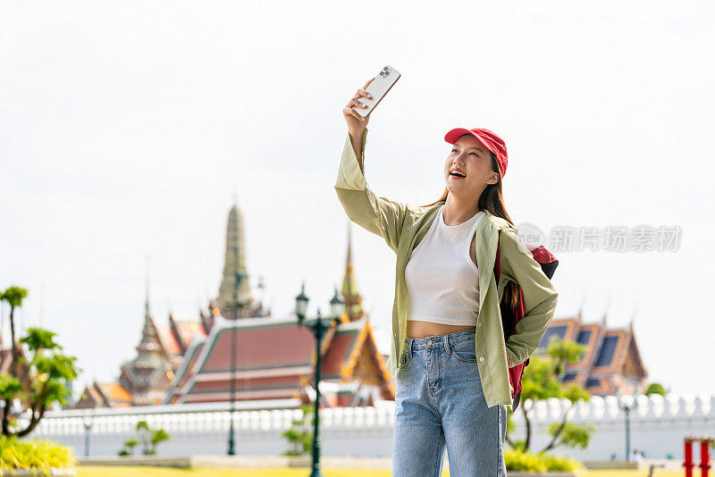 亚洲女性独自旅行者在卧佛寺和大皇宫外捕捉瞬间和自拍