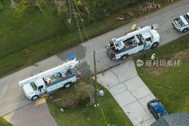鸟瞰图:飓风“伊恩”过后，在佛罗里达郊区，电工工人正在修理损坏的电线