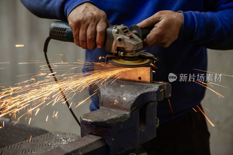 用角磨机切割钢材的重工业工人。