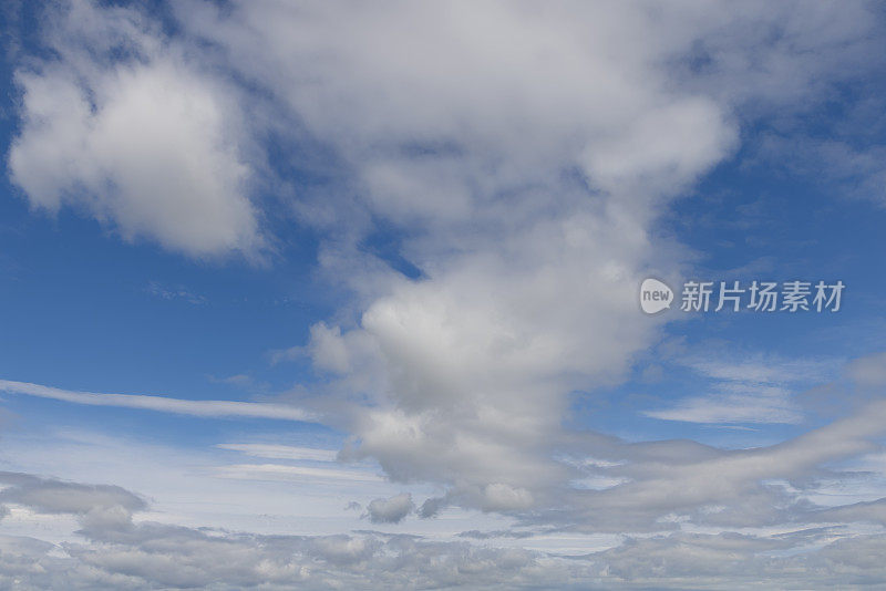 宁静，鼓舞人心的蓝天和蓬松的云延伸到地平线作为背景