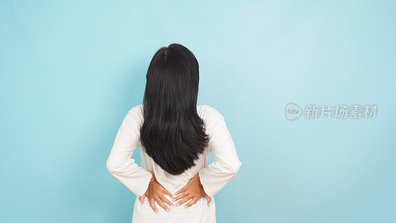 浅蓝色背景的亚洲女性因月经而腰痛