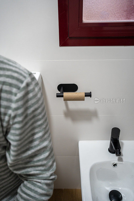 厕所里一个面目全非的男人厕纸用完了。对一个急着上厕所的人来说真是麻烦。