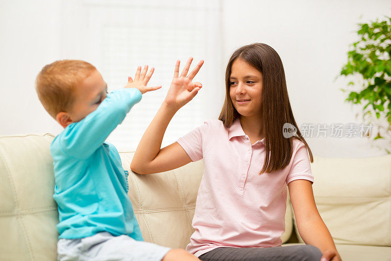 弟弟和妹妹在家里学习手语
