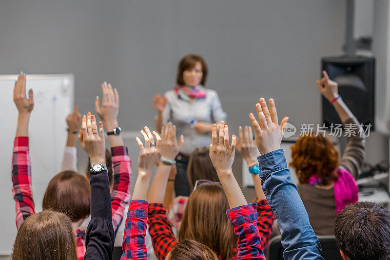 积极的学生举起手臂准备回答老师的问题