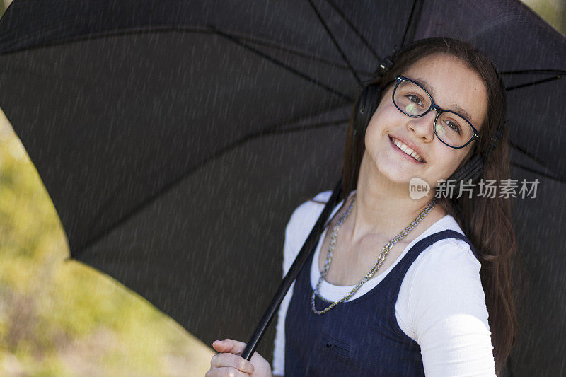 美丽的少女在雨天听音乐